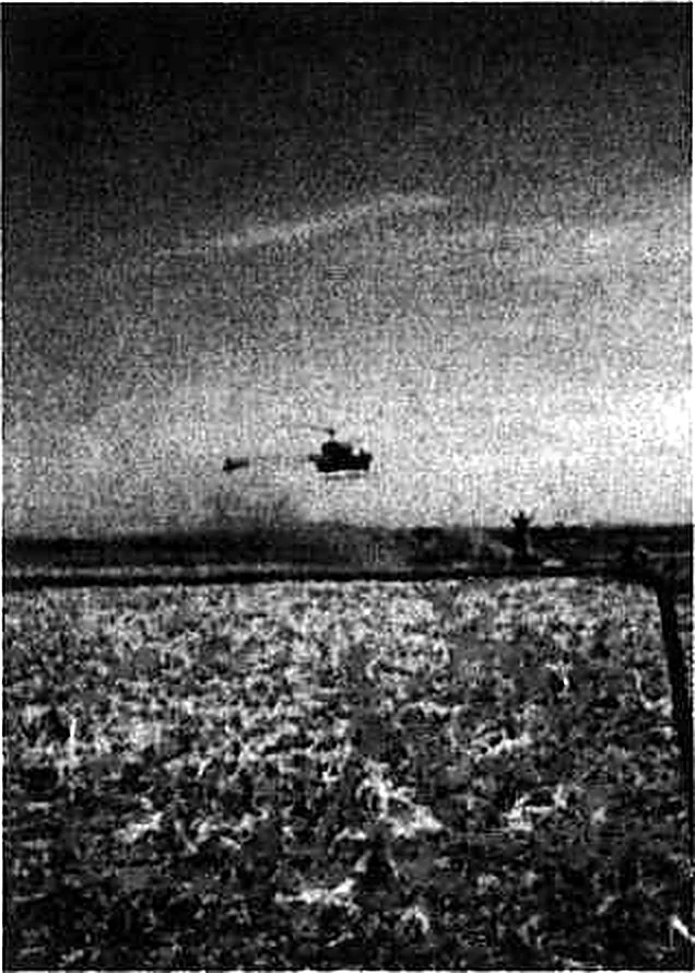 A helicopter coming in low over a field to evacuate a wounded soldier